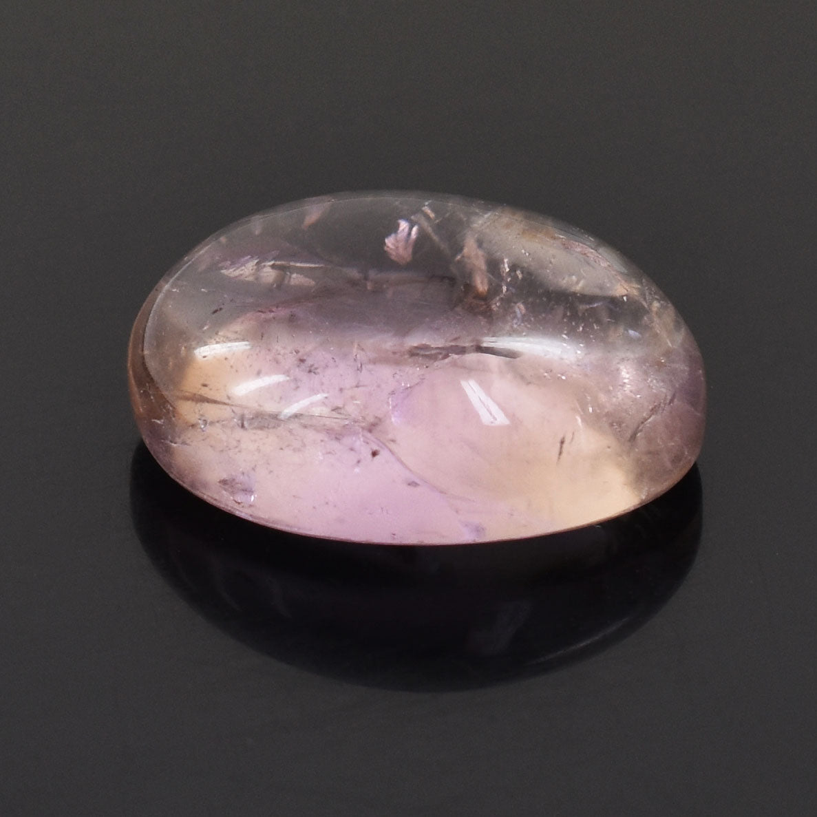 Oval-shaped, translucent pink gemstone with internal inclusions.