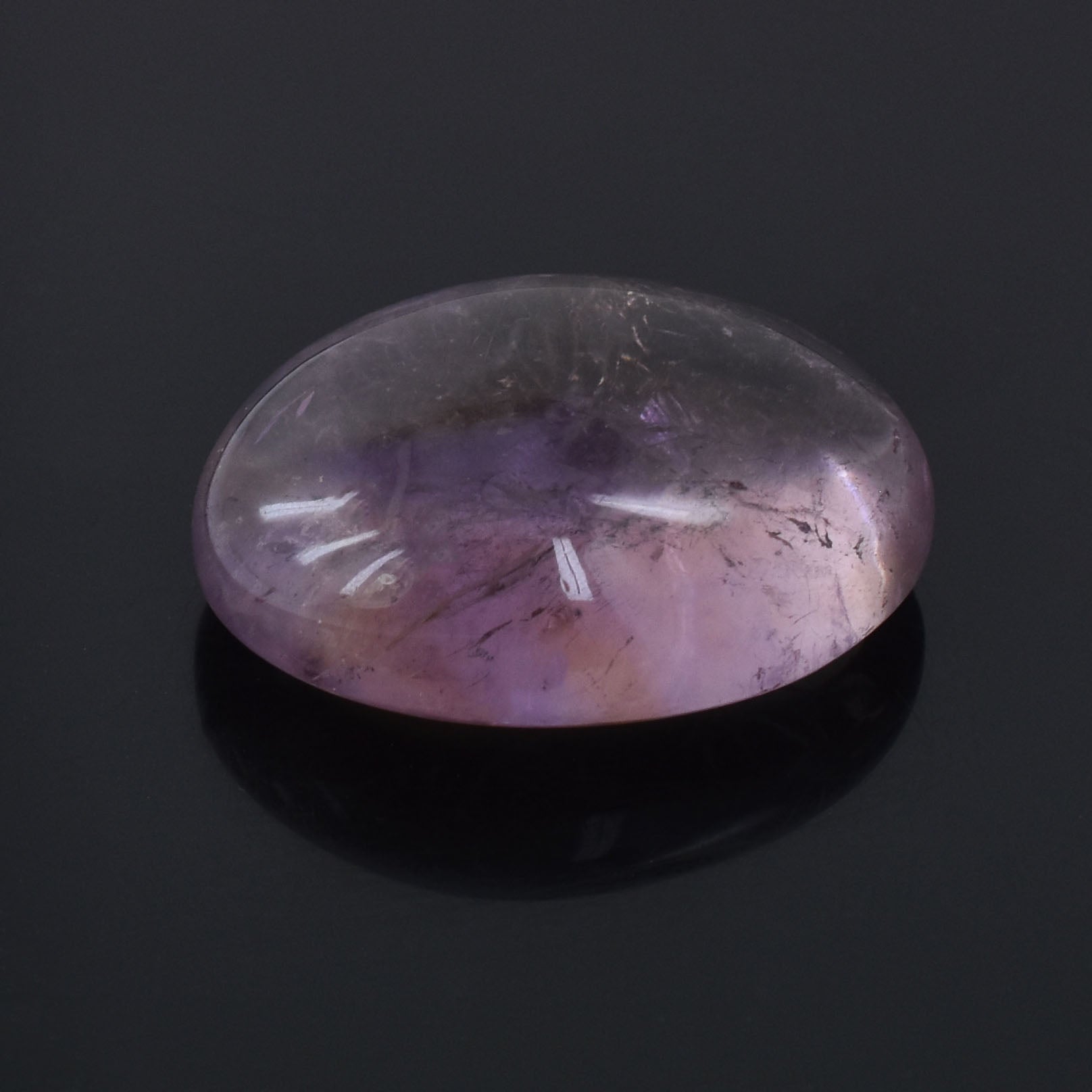 Oval-shaped purple gemstone with internal inclusions.