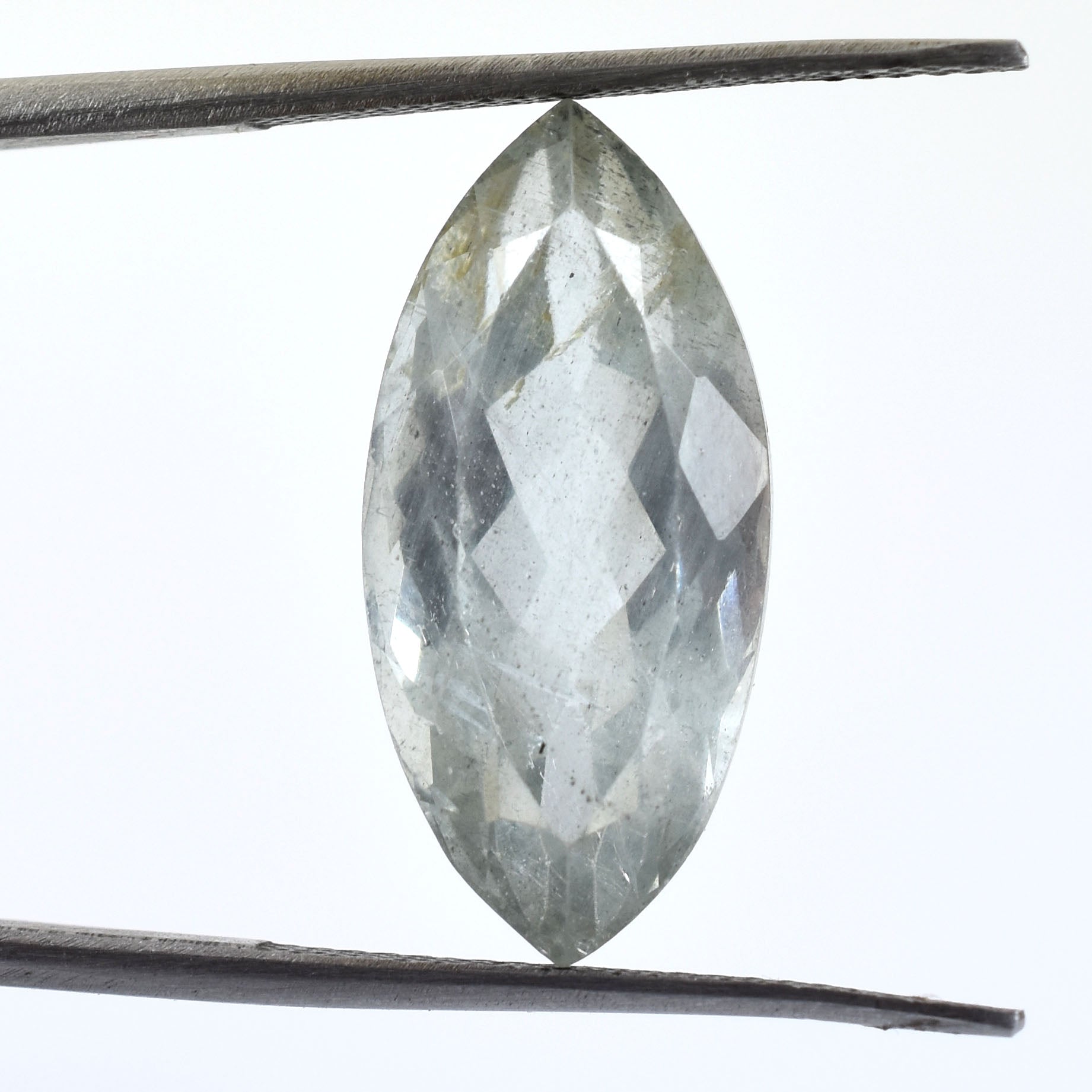 Marquise-cut gemstone held between tweezers.