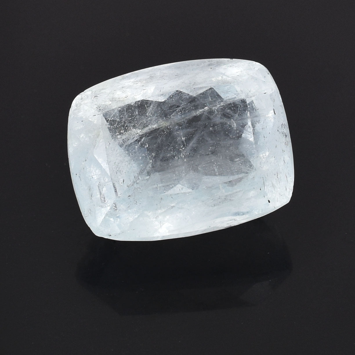 Rough, translucent crystal or gemstone with a cushion-cut shape.