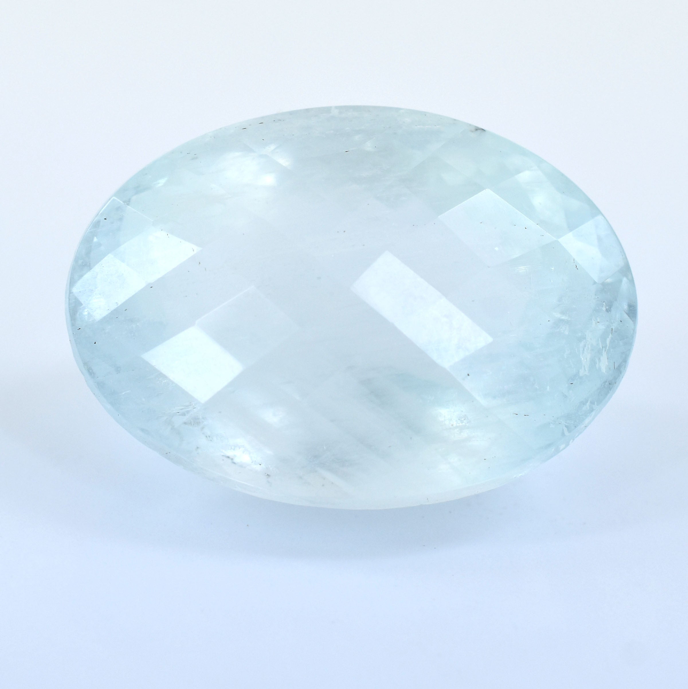 Oval-shaped, pale blue gemstone with faceted surfaces.