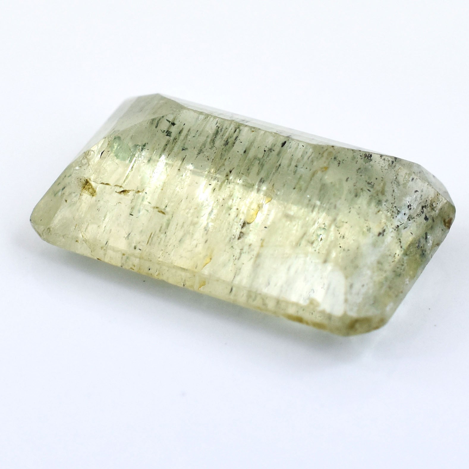 Pale green, translucent crystal with a rectangular shape and striations.