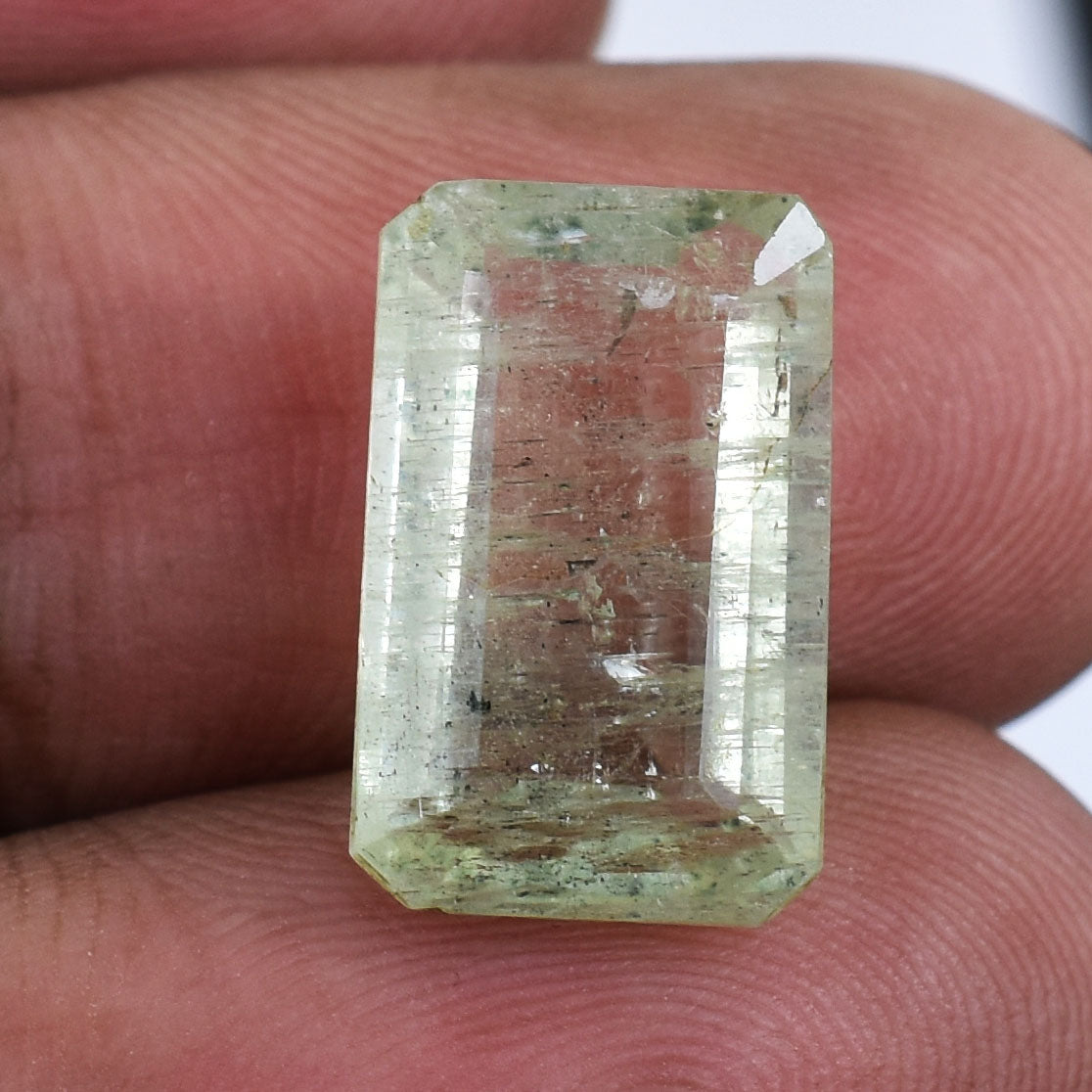 Rectangular-cut pale green gemstone with visible inclusions.