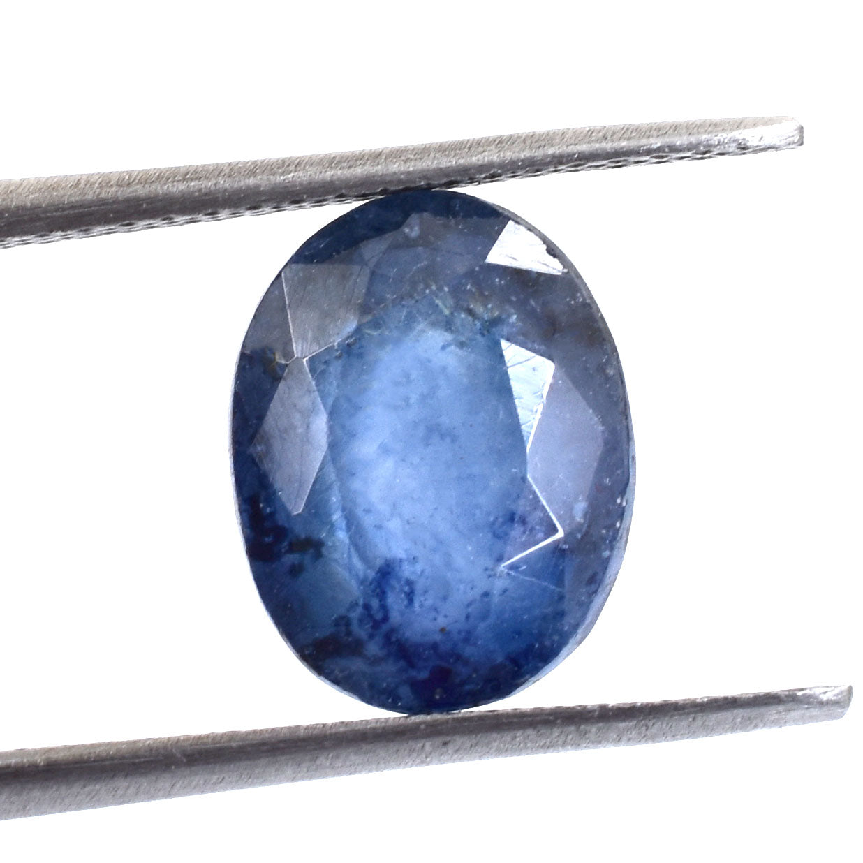 Oval-cut blue sapphire gemstone held by tweezers.