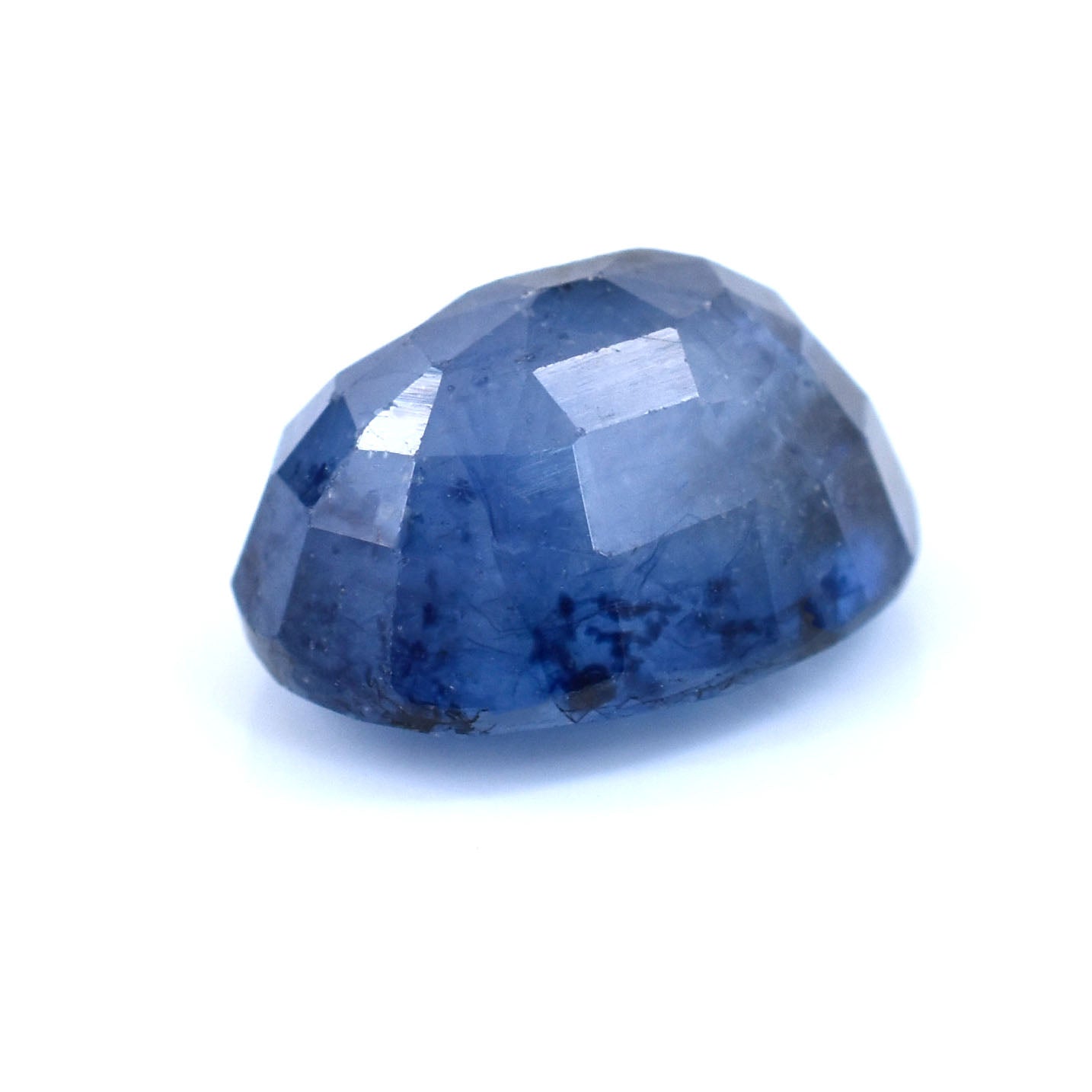 Oval-shaped blue gemstone with faceted surface and slight inclusions.