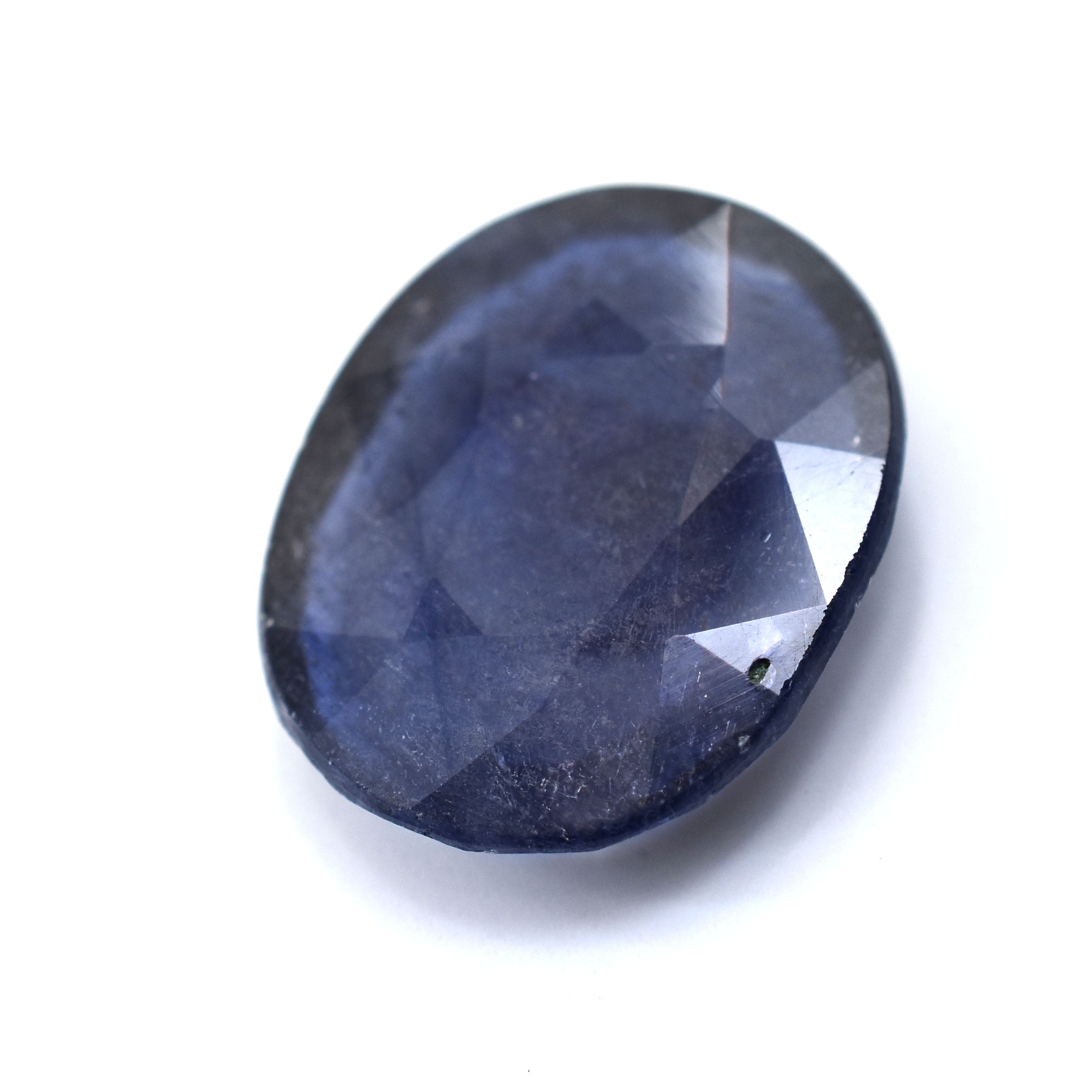 Oval-cut blue gemstone with facets reflecting light.