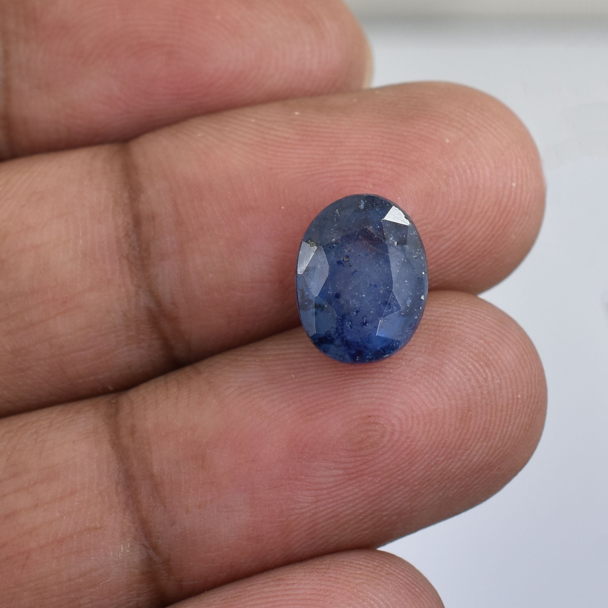 Oval-cut blue gemstone, likely a sapphire.