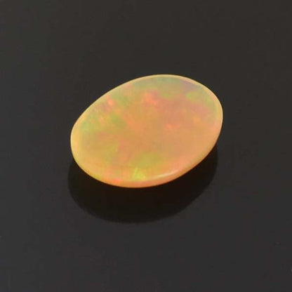 Oval-shaped opal gemstone with iridescent yellow and orange hues.