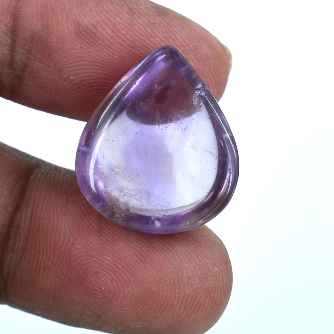 Teardrop-shaped purple gemstone or crystal held between fingers.