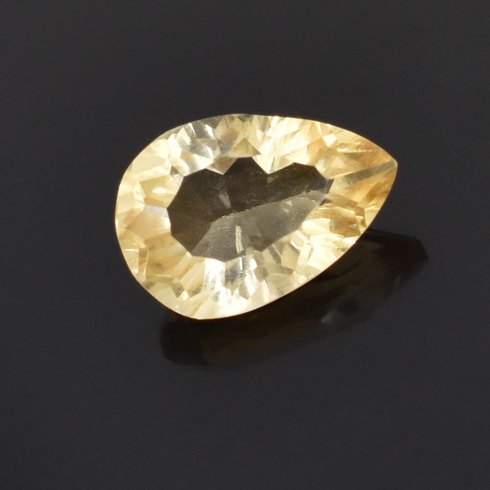 Teardrop-shaped pale yellow gemstone with faceted cuts.