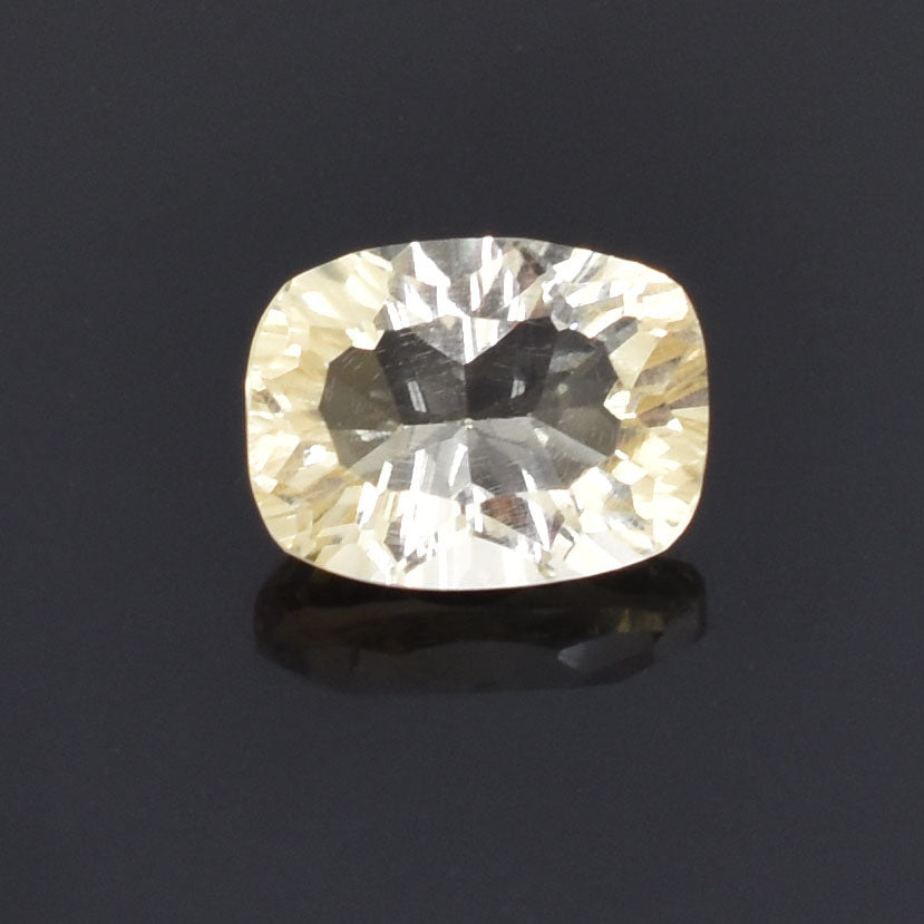 Cushion-cut gemstone with a pale yellow hue and brilliant facets.