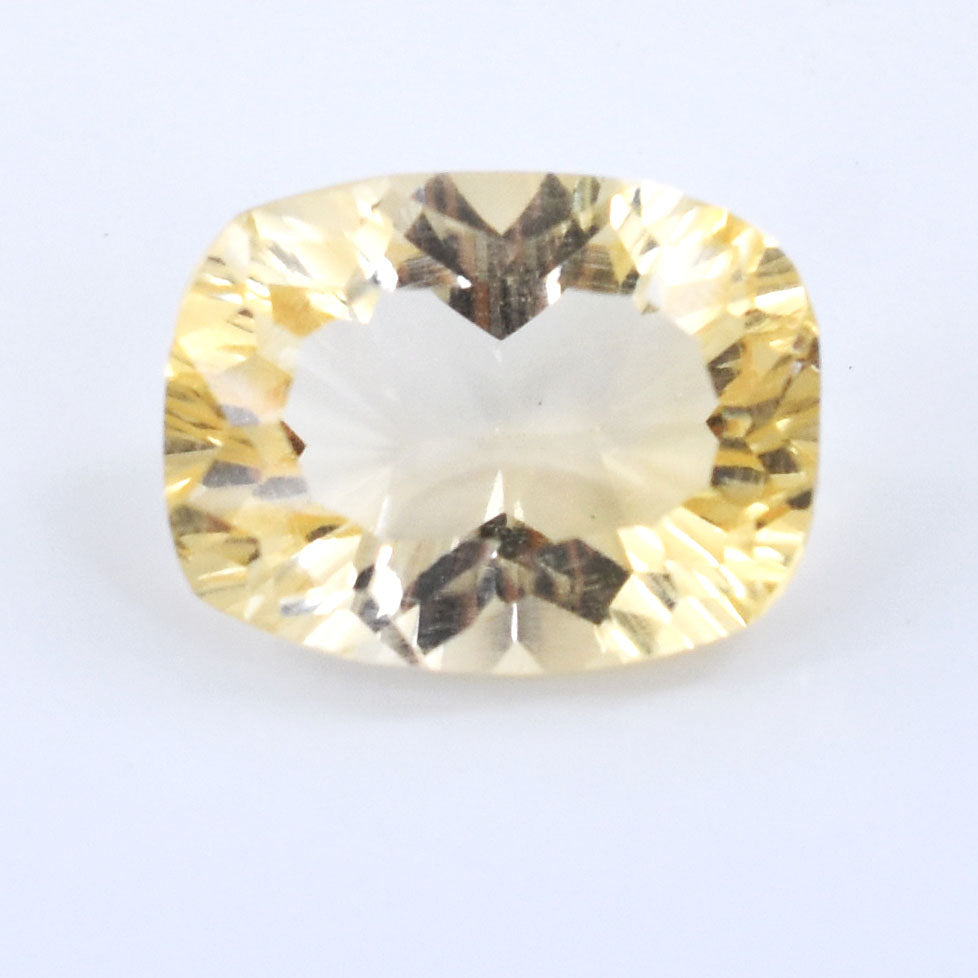 Cushion-cut pale yellow gemstone with faceted edges.