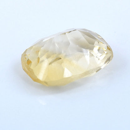 Pale yellow, oval-shaped gemstone with faceted cuts.