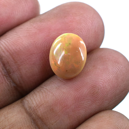 Oval-shaped opal gemstone with a warm yellow-orange hue.