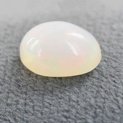 Smooth, oval-shaped opal gemstone with a milky white color and subtle iridescence.