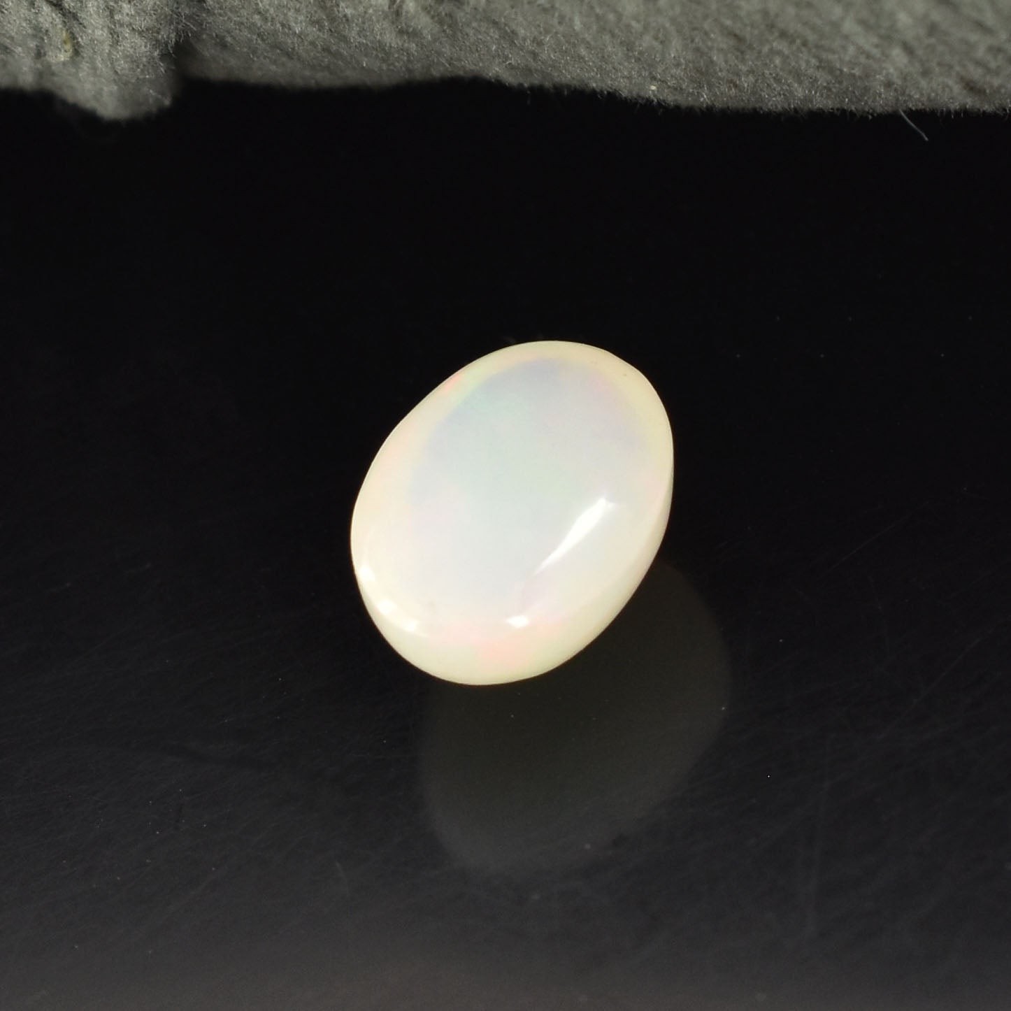 Oval-shaped opalescent gemstone or cabochon.