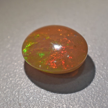 Opal gemstone with flashes of green and red fire.