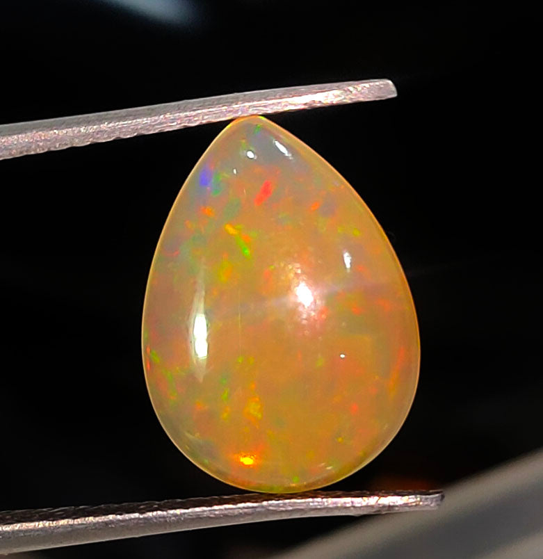 Teardrop-shaped opal gemstone with vibrant multicolored flashes.