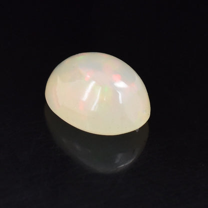 Opalescent gemstone with a smooth, rounded cabochon cut.