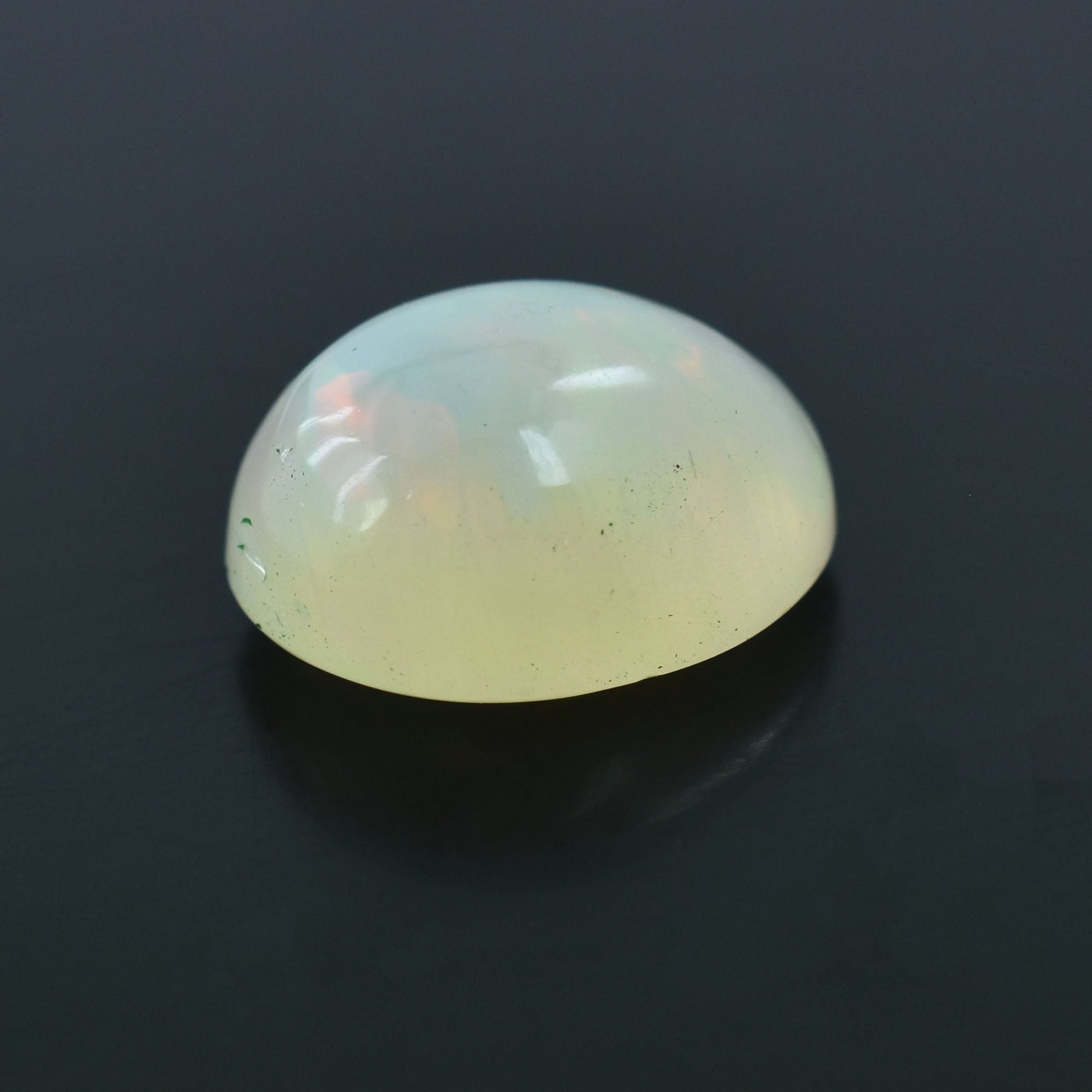 Oval-shaped, translucent gemstone with a milky white color and subtle iridescence.