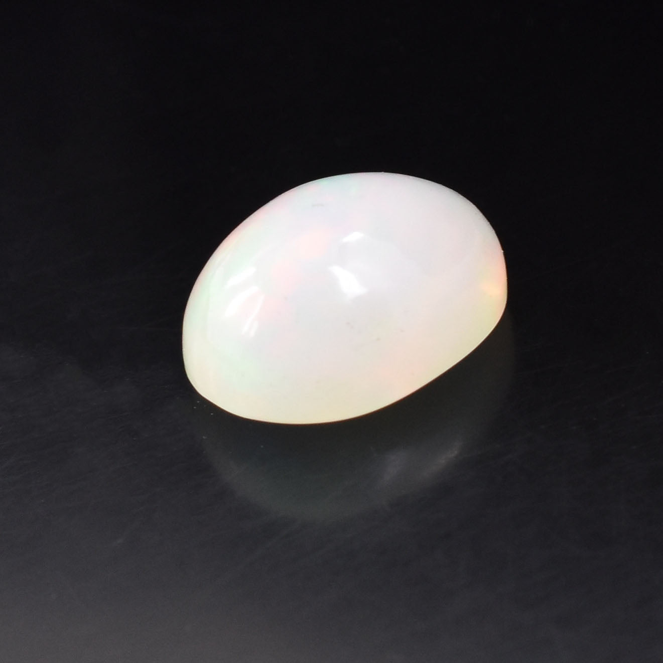 White, oval-shaped egg on a reflective surface.