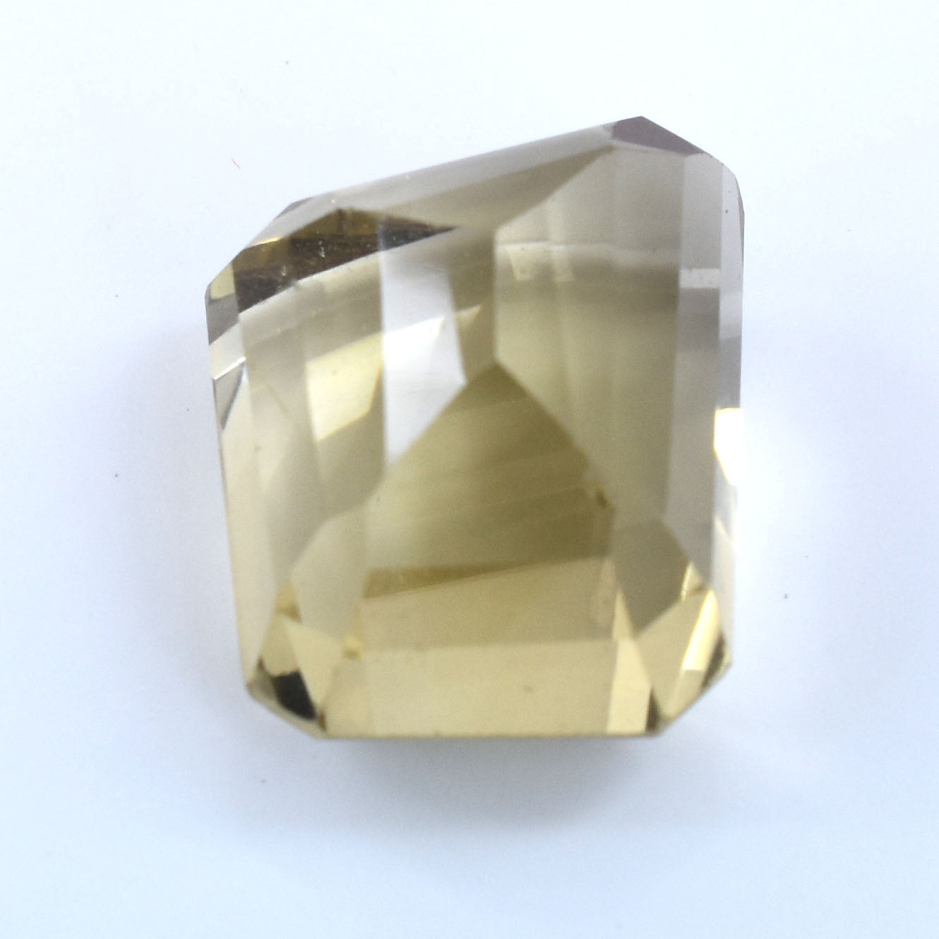 Faceted pale yellow gemstone or crystal with angular cuts.