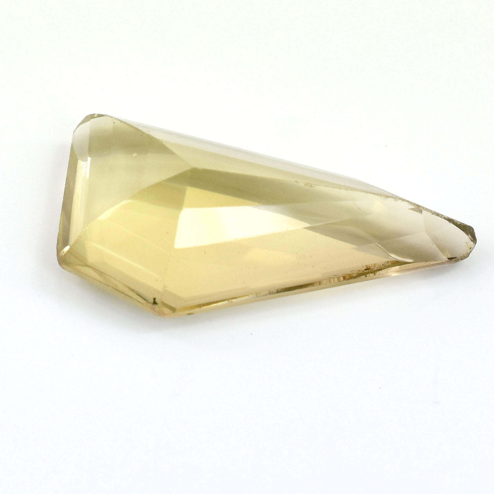 Faceted, pale yellow gemstone with a triangular shape.