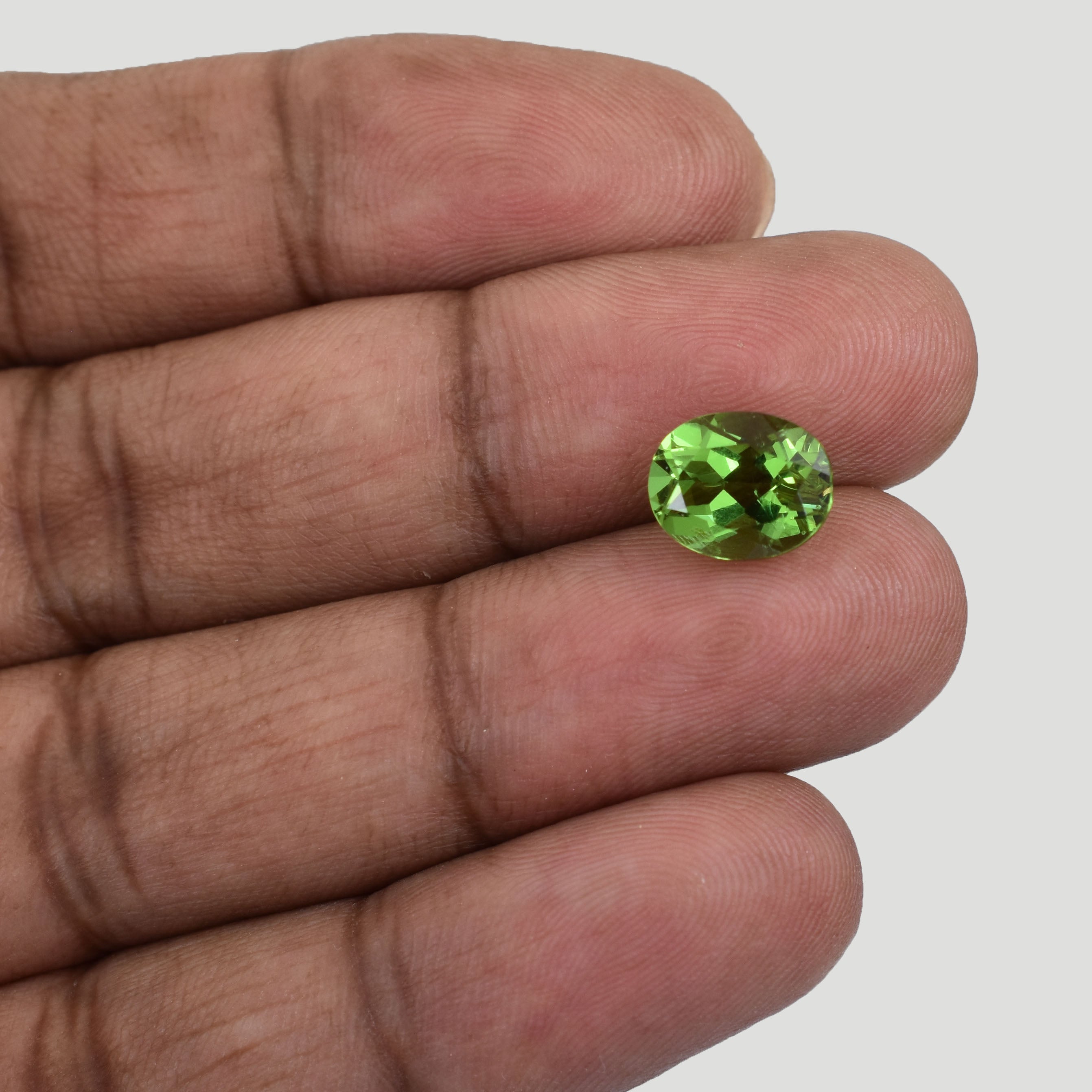 Oval-cut bright green gemstone, likely peridot.