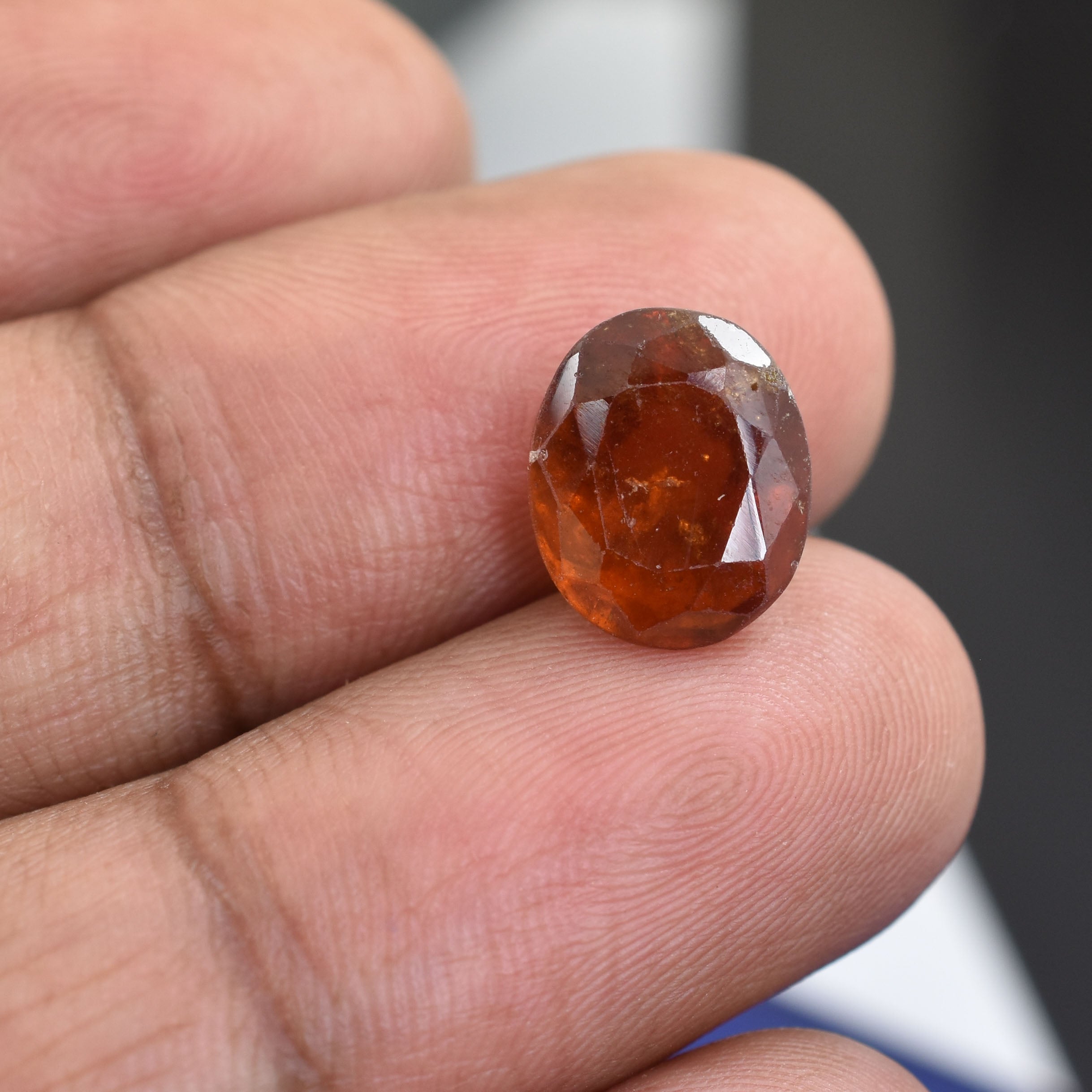 Faceted oval gemstone with a deep amber color.