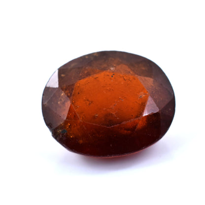 Oval-cut, deep reddish-brown gemstone with facets.