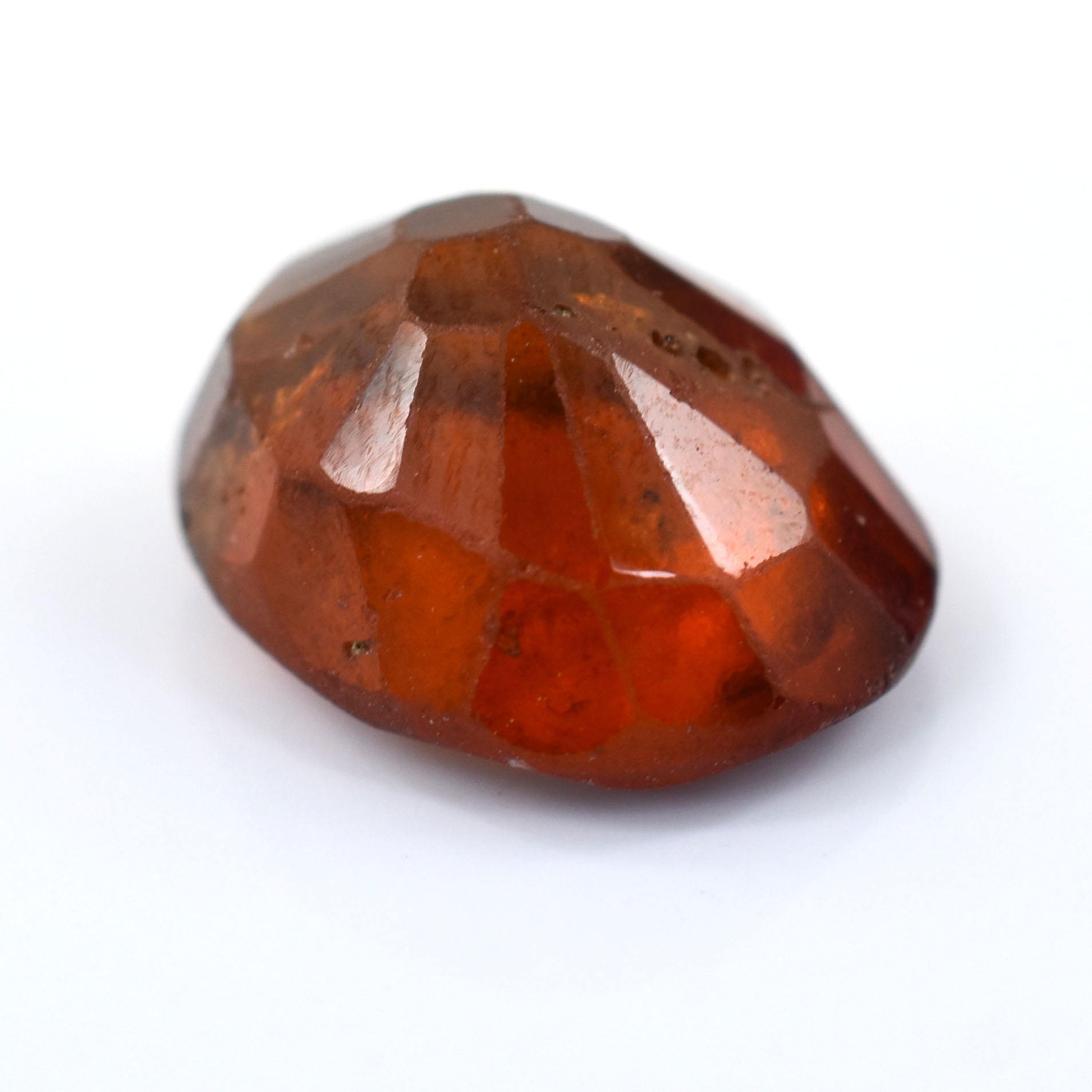 Faceted, reddish-orange gemstone with a round, brilliant cut shape.