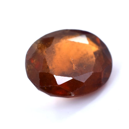 Oval-cut gemstone with a deep reddish-brown color.