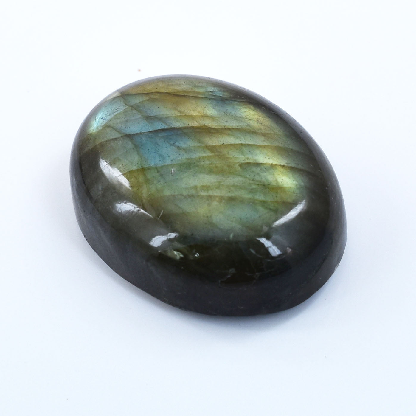 Polished oval labradorite gemstone displaying iridescent blue and green flashes.