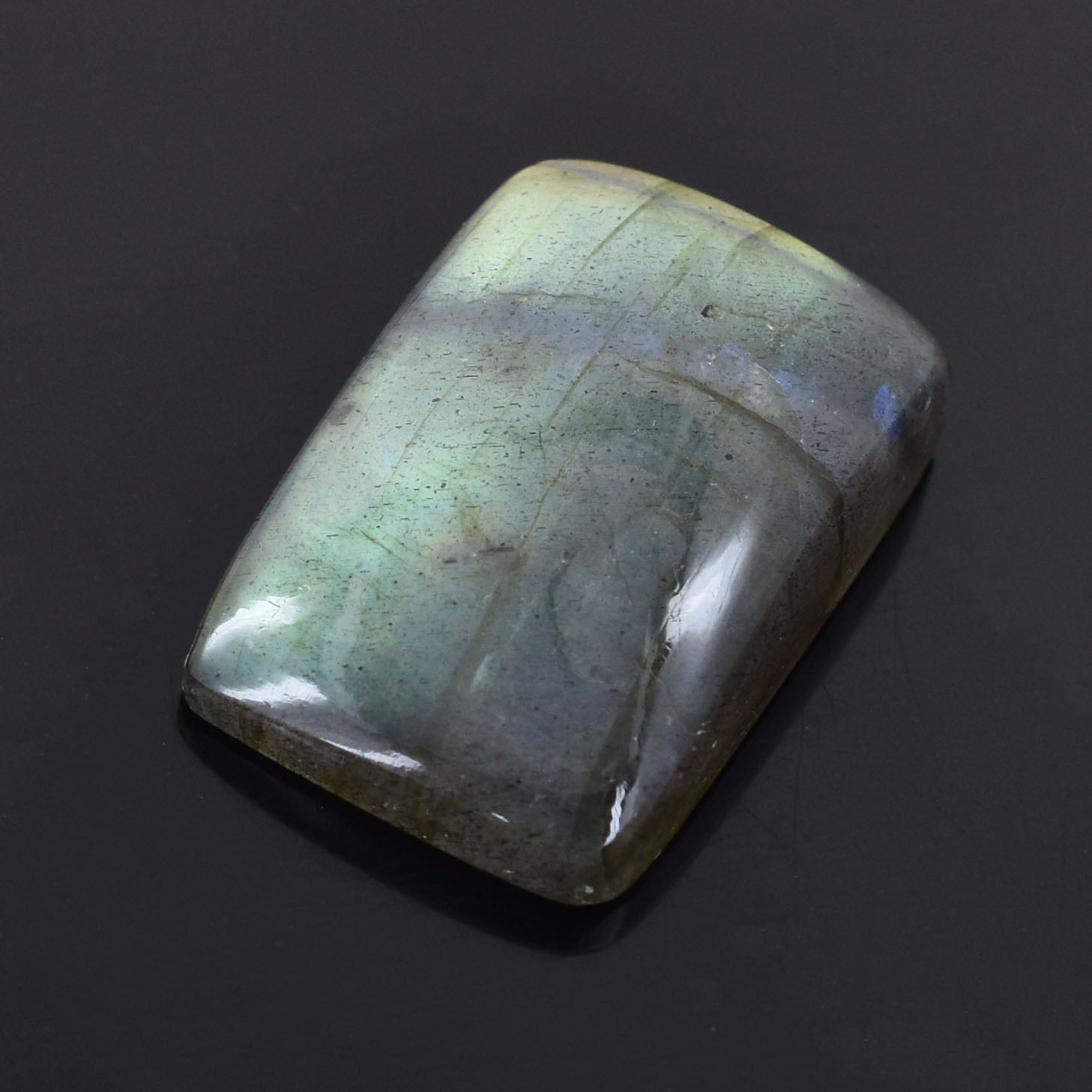 Polished labradorite gemstone with iridescent blue-green flashes.