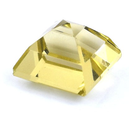 Faceted yellow gemstone or crystal with a square-shaped base and pyramidal top.