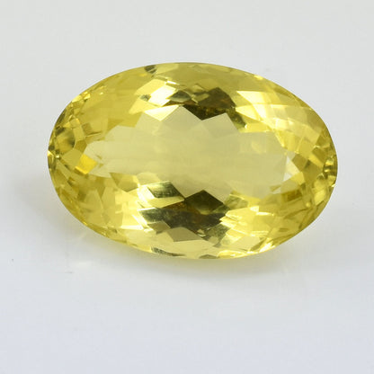 Oval-cut yellow gemstone with faceted surfaces.