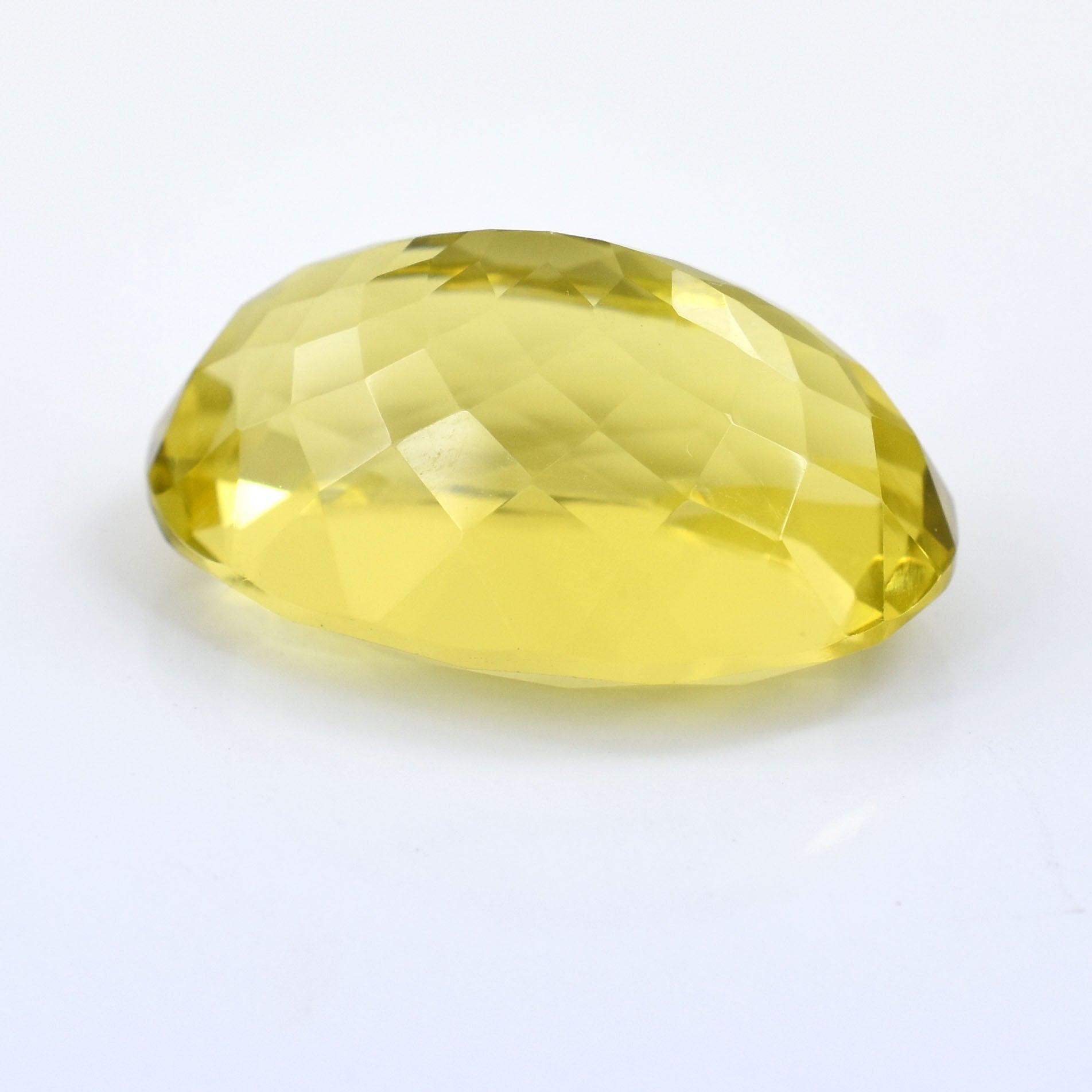 Faceted yellow gemstone with an oval shape.