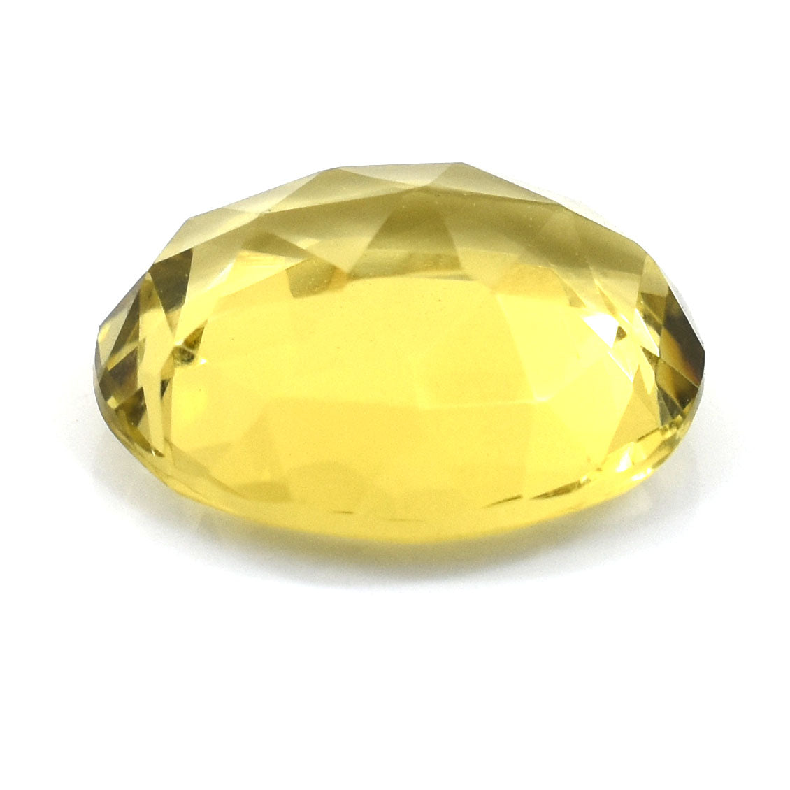 Oval-cut yellow gemstone with faceted edges.