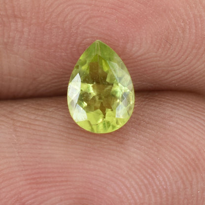 Pear-shaped, light green gemstone with facets.