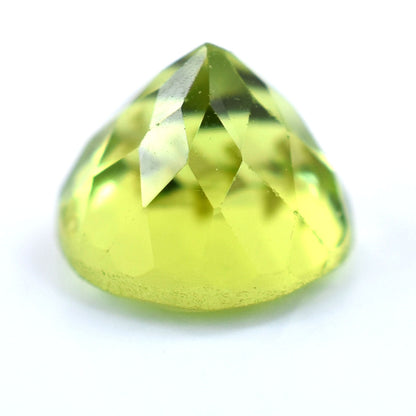 Faceted light green gemstone with a triangular shape.