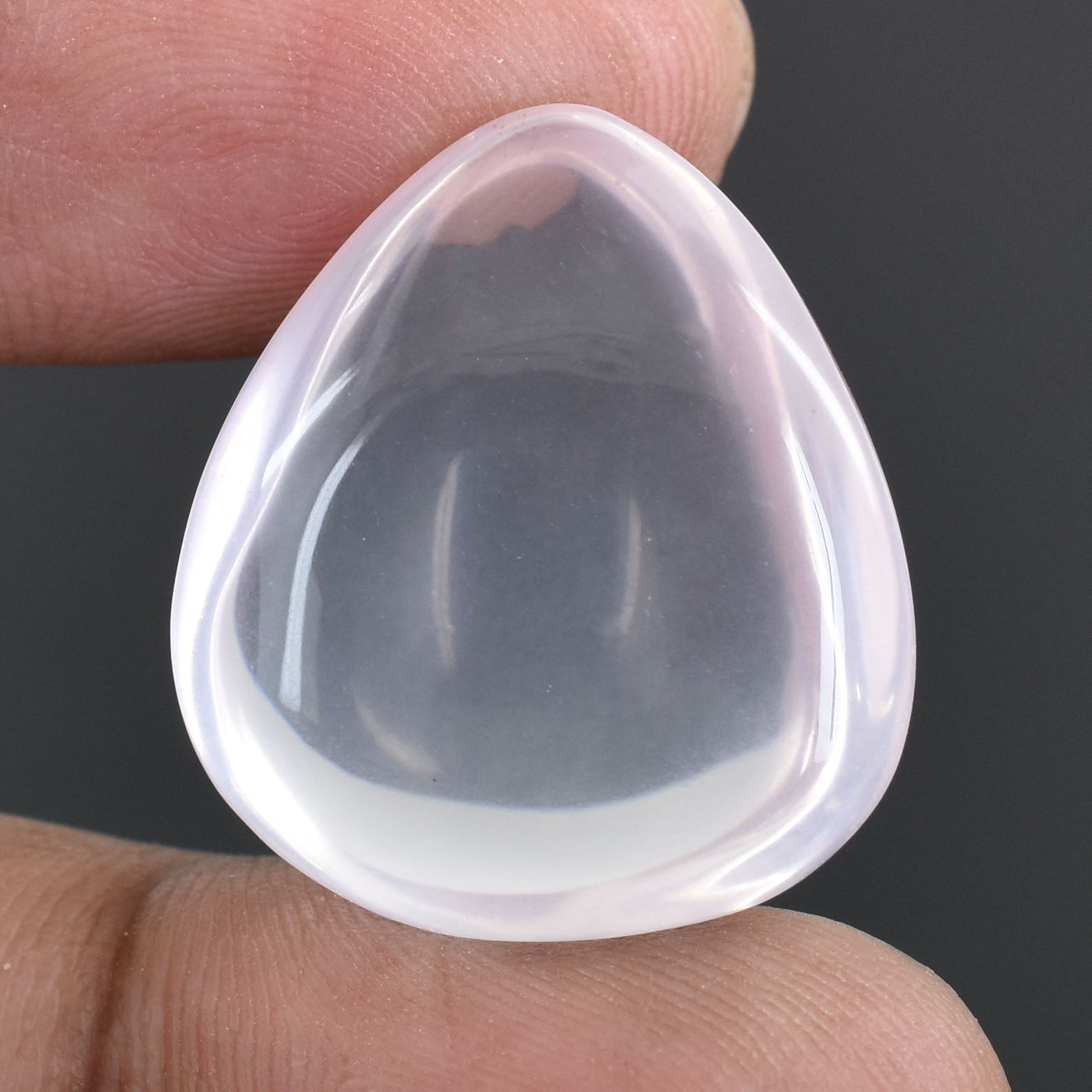 Teardrop-shaped silicone or plastic insert, likely a contact lens or prosthetic eye.