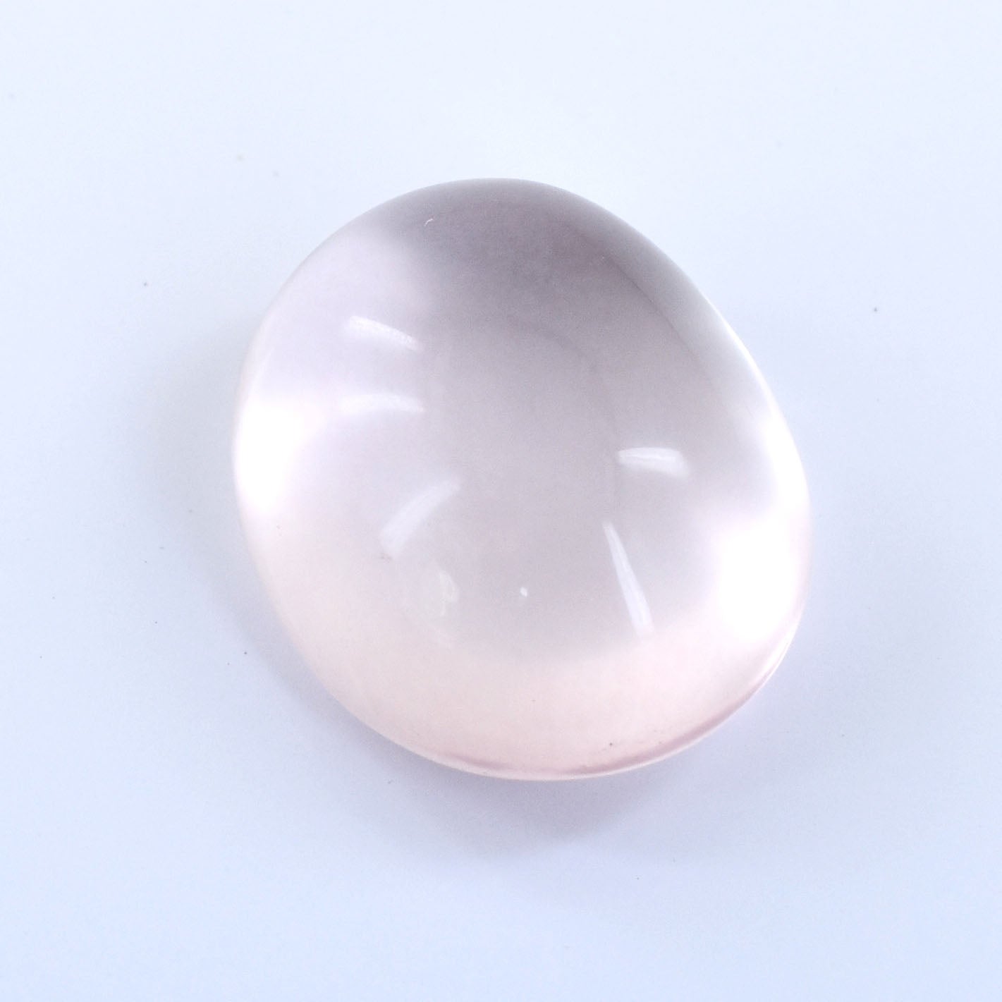 Pale pink oval gemstone with a smooth, polished surface.