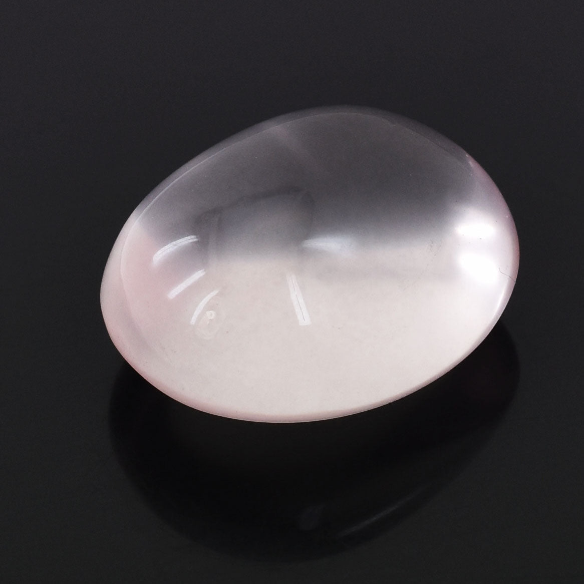 Smooth, oval-shaped pale pink gemstone or cabochon with a soft, milky luster.