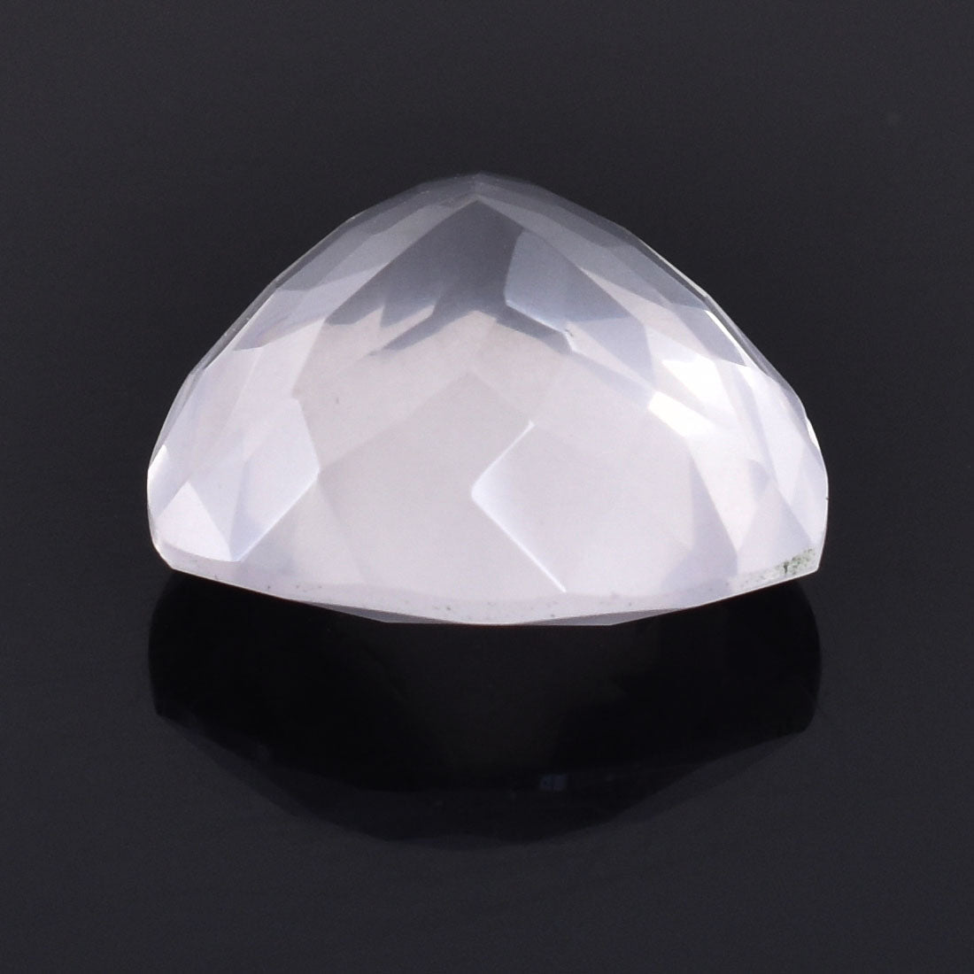 Faceted white gemstone or crystal with a domed shape.