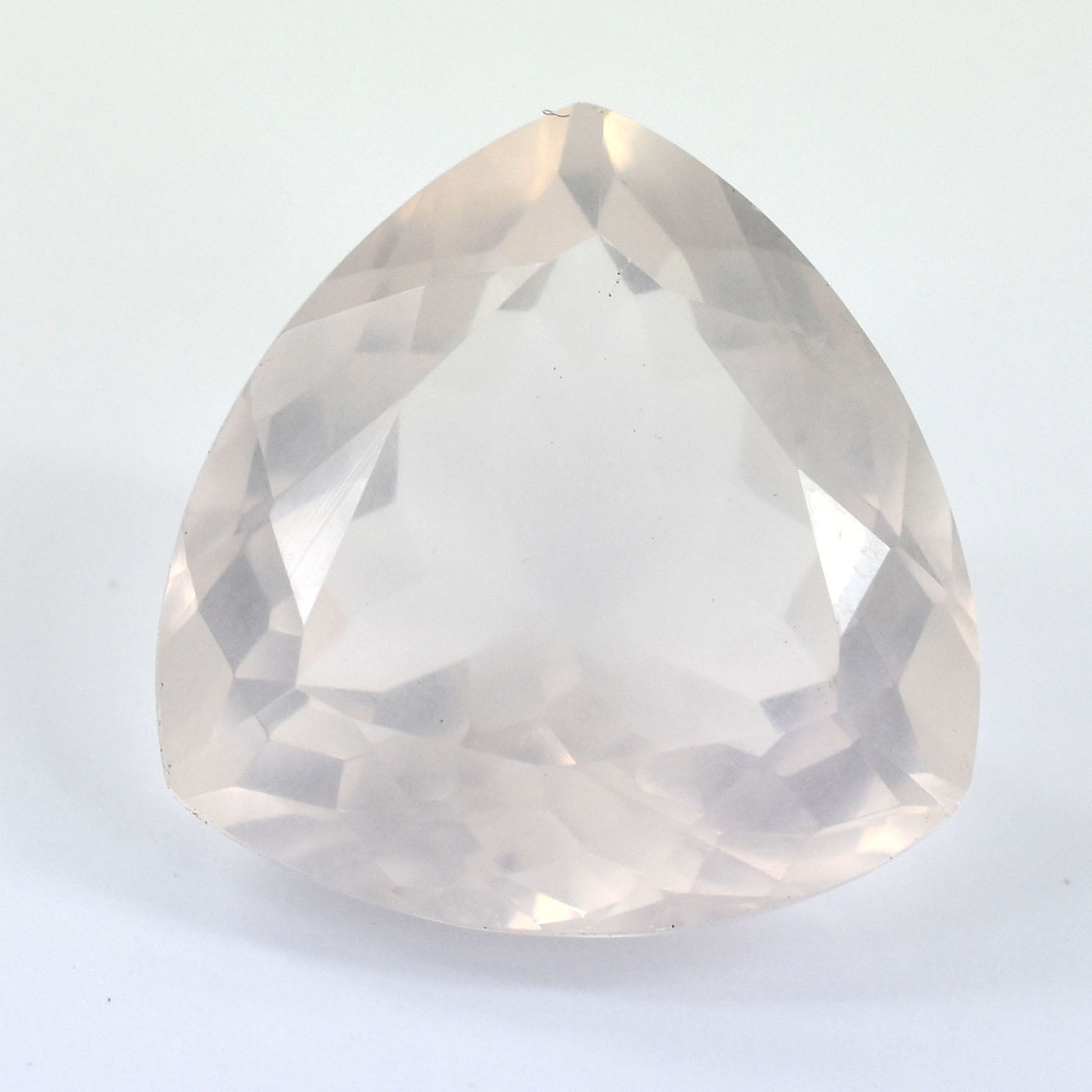 Triangular-cut, translucent gemstone with a pale, milky appearance.