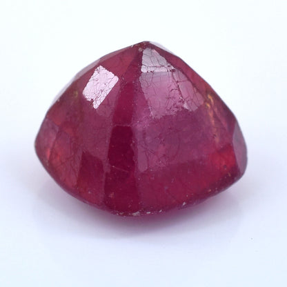 Deep red, faceted gemstone with a rounded triangular shape.