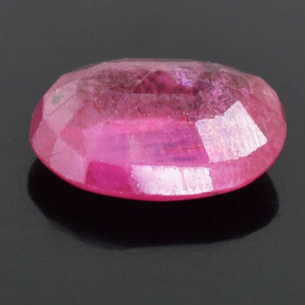 Faceted pink gemstone with a vibrant rose hue and reflective surface.