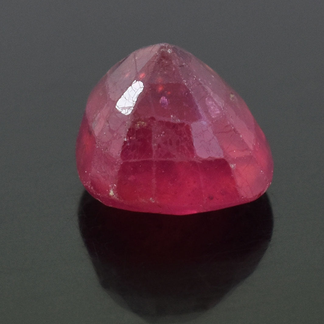 Faceted pink gemstone with a rounded triangular shape.