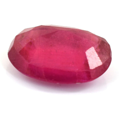 Faceted oval ruby gemstone with a vibrant pink-red color.