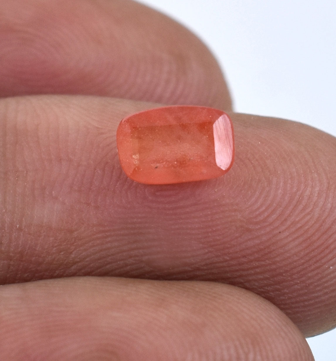 Orange-pink gemstone with a rectangular cushion cut.